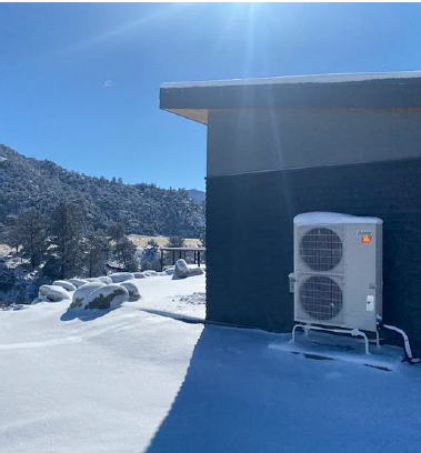 Outdoor heat pump beside a home in winter